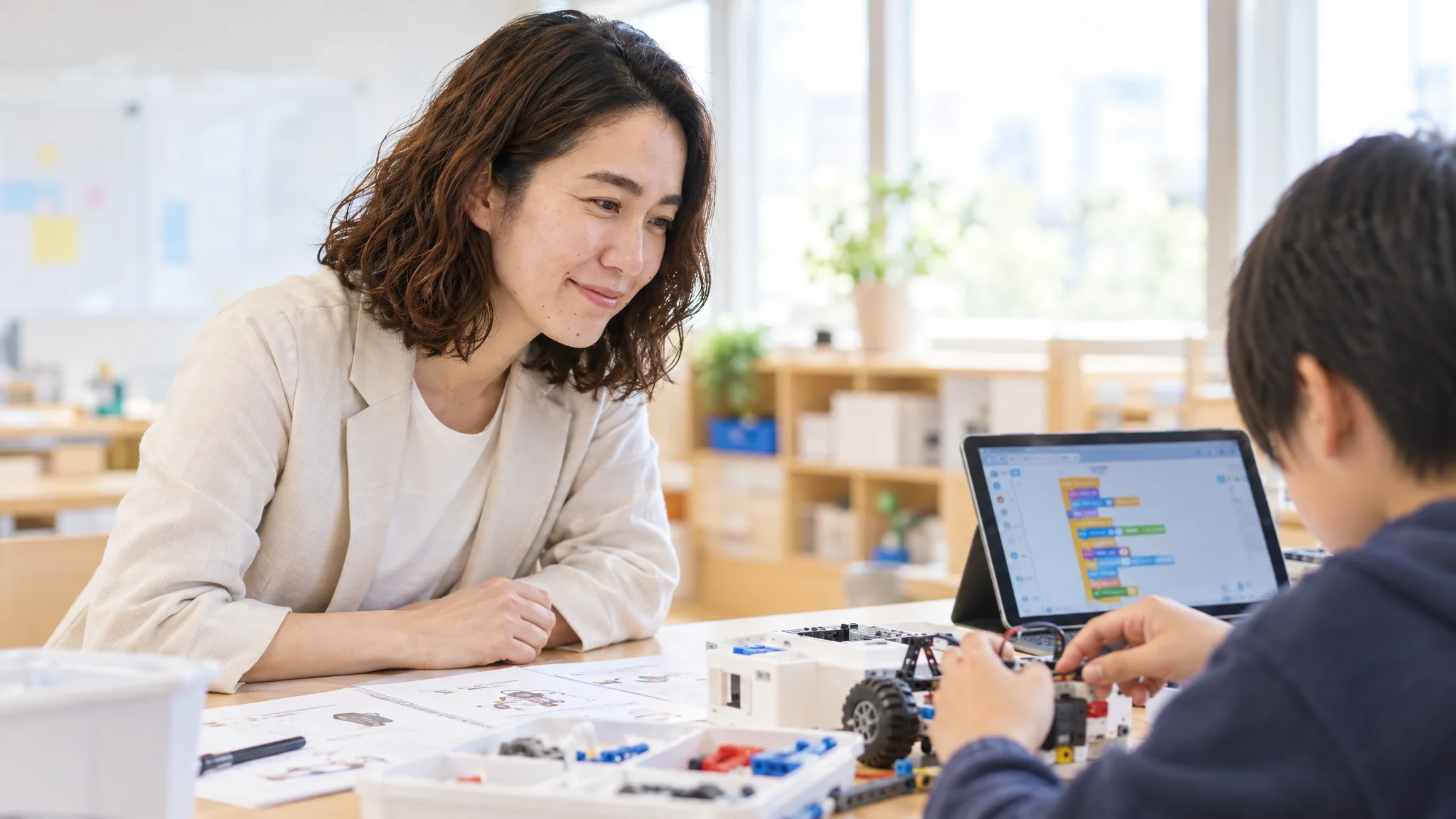 日本のモダンなオフィスで、教育事業の収益シミュレーションを確認しているビジネスパーソン。デスクには日本語の経営計画書と、売上目標を示すチャートが表示されたノートPCが置かれている。企業の看板などが写らない整理された会議室。